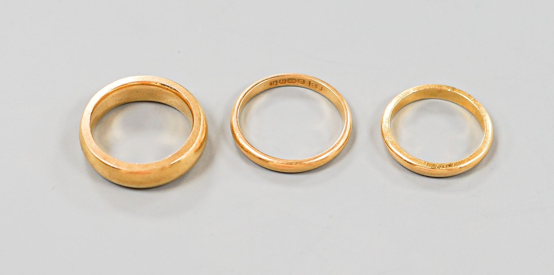 Two 22ct gold wedding bands, 7.1 grams and one other heavy yellow metal band, 12.1 grams.